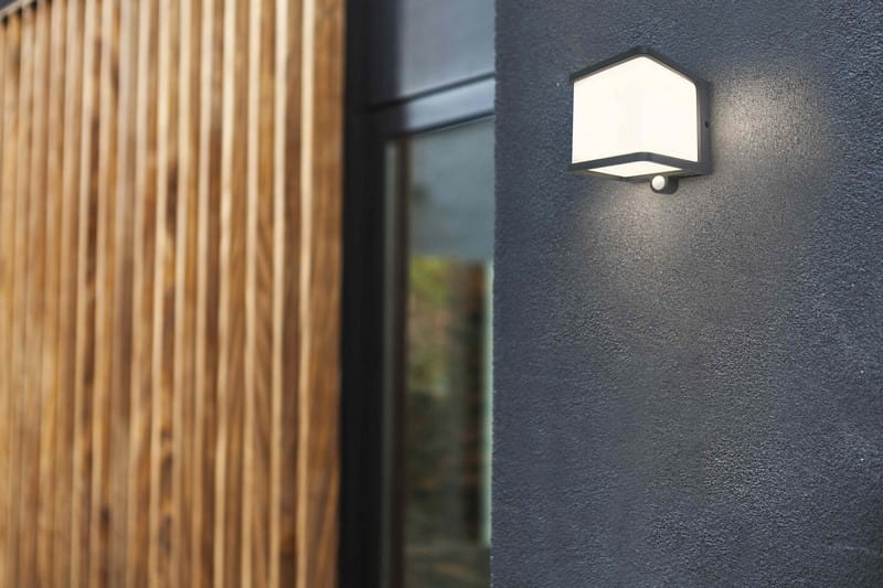 Kinkiet zewnętrzny z czujnikiem Lutec Doblo Solar 6940101125 IP54 1xLED Aluminium Szary zamontowany na ścianie budynku.